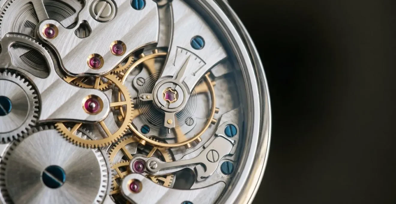 Gros plan sur un mouvement horloger squelette révélant la mécanique complexe et les finitions artisanales